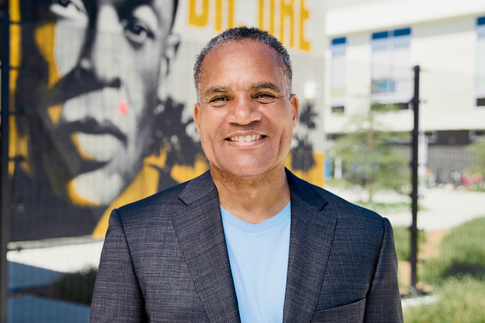 Darin Brawley stands in front of a mural outdoors