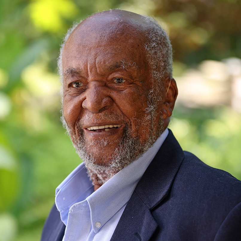 Headshot of Dr. Edmund Gordon against green nature